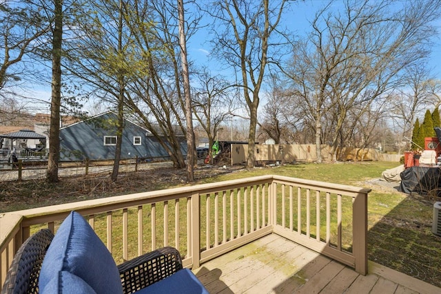 wooden terrace with fence private yard, a lawn, and an outbuilding