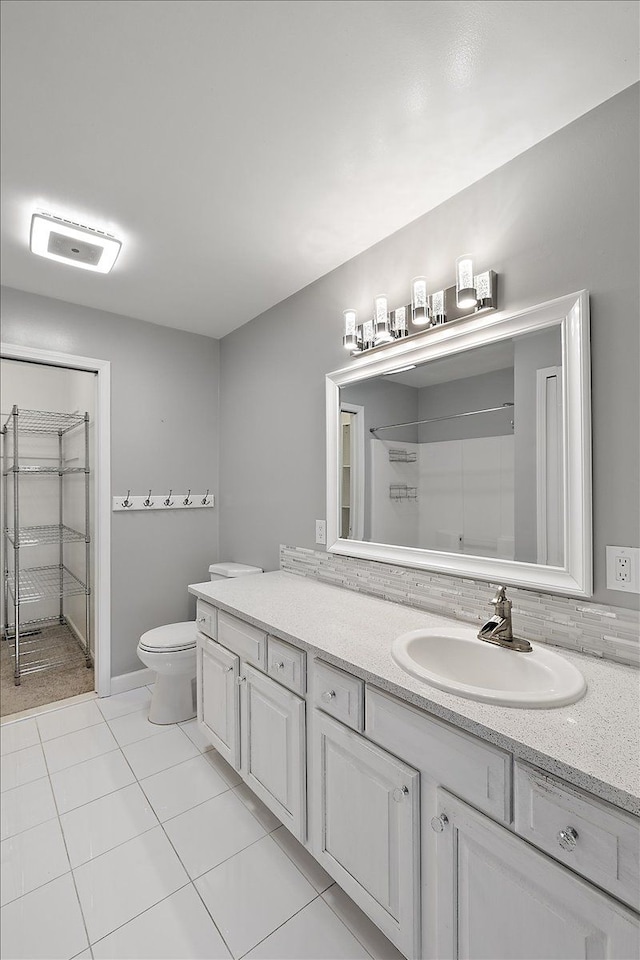 bathroom with a shower, visible vents, toilet, vanity, and tile patterned floors