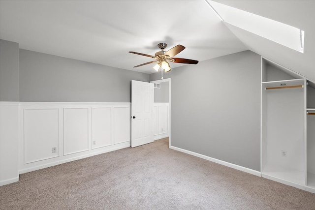 additional living space with light carpet, ceiling fan, a decorative wall, and lofted ceiling