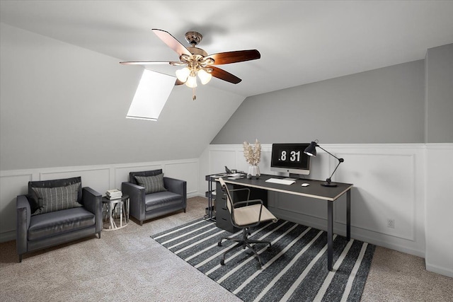 office space featuring a wainscoted wall, ceiling fan, vaulted ceiling, carpet flooring, and a decorative wall