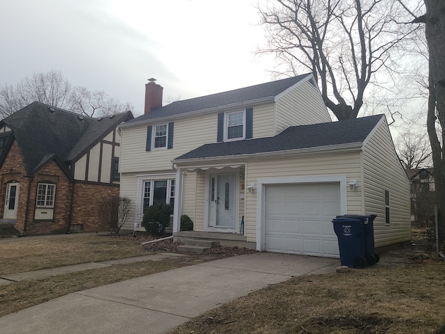 view of front of property featuring driveway, a chimney, and an attached garage