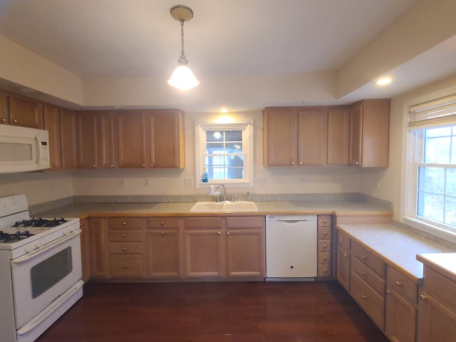 kitchen with white appliances, dark wood-style flooring, a sink, light countertops, and pendant lighting