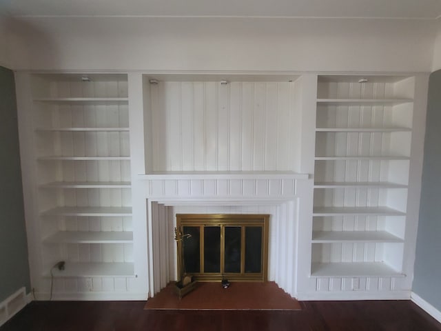 room details with built in shelves and a glass covered fireplace