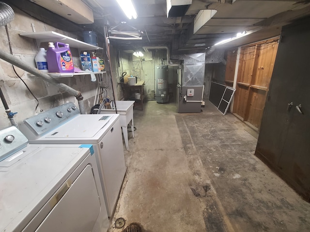 washroom with laundry area, washer and clothes dryer, heating unit, water heater, and a sink