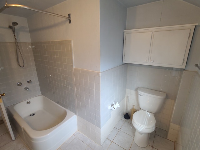 full bathroom featuring tile walls, toilet, wainscoting,  shower combination, and tile patterned flooring