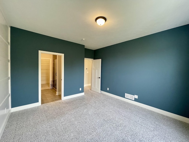 unfurnished bedroom featuring carpet, visible vents, and baseboards