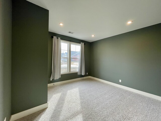 carpeted spare room featuring recessed lighting, visible vents, and baseboards