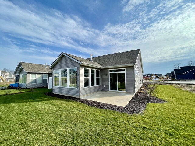 rear view of house with a patio and a lawn