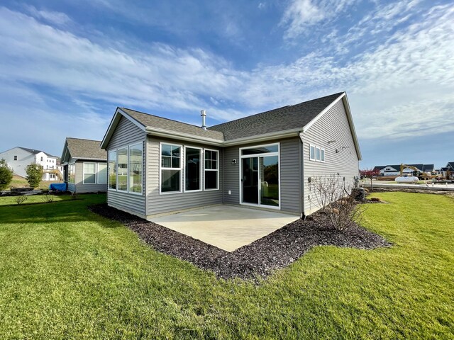 rear view of house with a yard and a patio