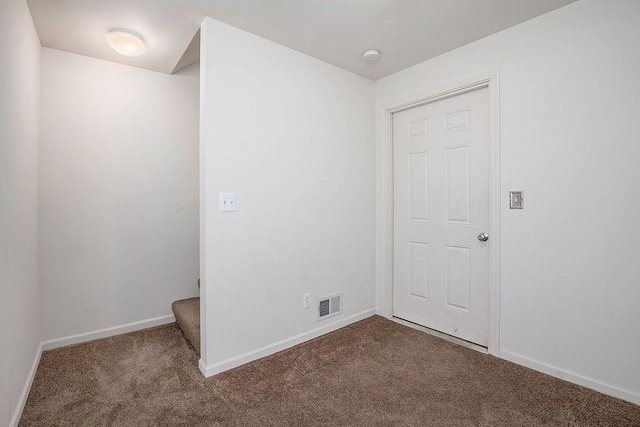 spare room with carpet, visible vents, and baseboards