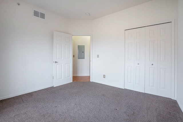 unfurnished bedroom featuring visible vents, baseboards, carpet, electric panel, and a closet