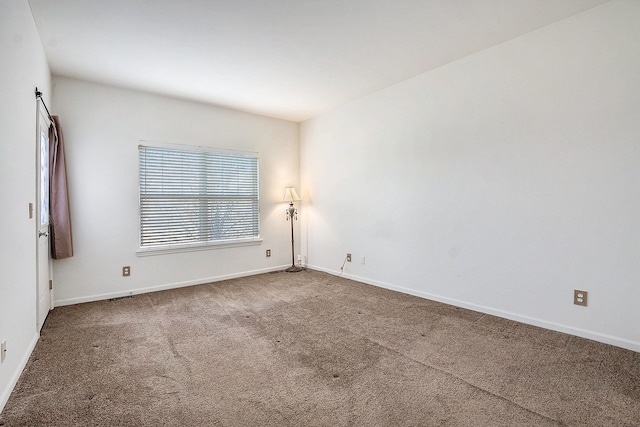 carpeted empty room with baseboards