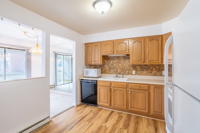 kitchen featuring white appliances, tasteful backsplash, light wood finished floors, baseboard heating, and a sink