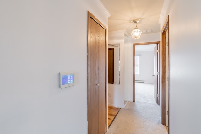 corridor with light carpet, baseboards, and crown molding