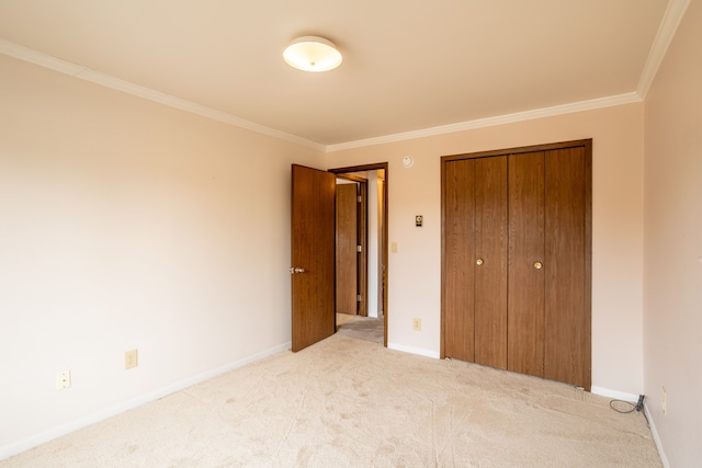 unfurnished bedroom with baseboards, a closet, carpet, and crown molding