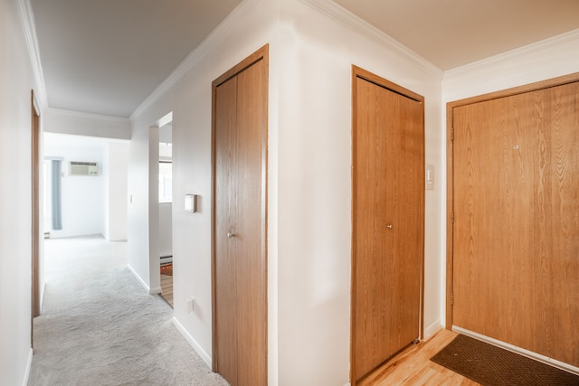 hall with a baseboard radiator, light colored carpet, baseboards, ornamental molding, and a wall mounted air conditioner