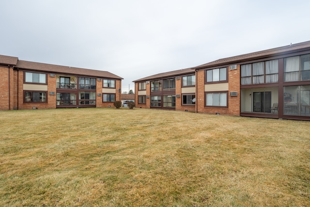 exterior space with brick siding and a lawn