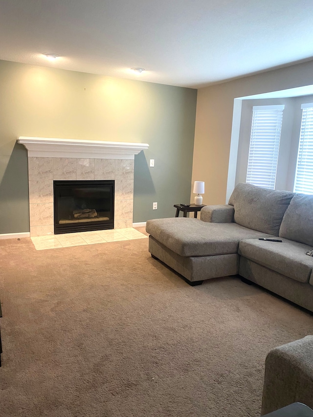 carpeted living room featuring baseboards and a tile fireplace