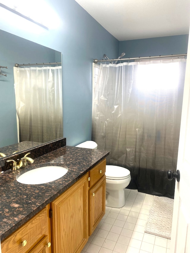 bathroom featuring a shower with shower curtain, toilet, vanity, and tile patterned flooring