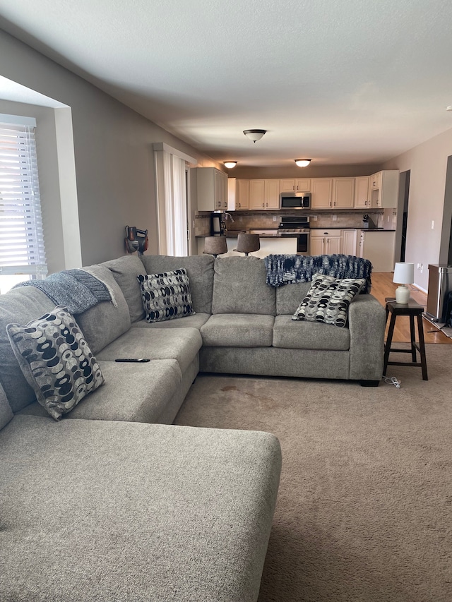 living room with a textured ceiling and light carpet