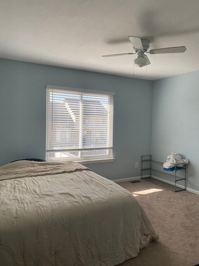 bedroom with a textured ceiling, a ceiling fan, baseboards, and carpet floors