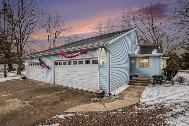 property exterior at dusk with an attached garage and driveway