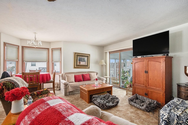 living area with light carpet, a chandelier, and a textured ceiling