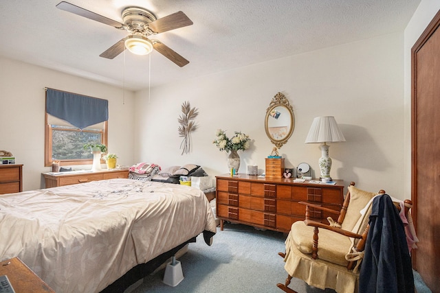 bedroom featuring carpet floors, ceiling fan, and a textured ceiling