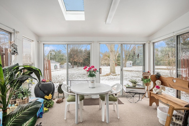 sunroom with lofted ceiling with skylight and plenty of natural light