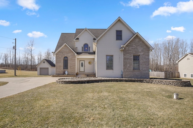 traditional-style home with a garage, brick siding, an outdoor structure, and a front yard