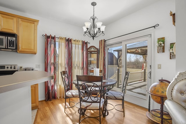 dining space featuring a notable chandelier and light wood-type flooring