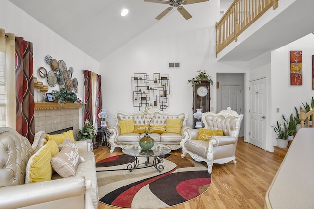 living area featuring visible vents, high vaulted ceiling, a ceiling fan, wood finished floors, and a fireplace