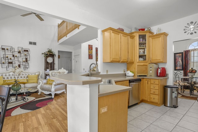 kitchen with visible vents, a peninsula, a sink, light countertops, and dishwasher