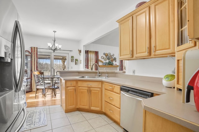 kitchen with a sink, light countertops, light brown cabinets, and stainless steel appliances