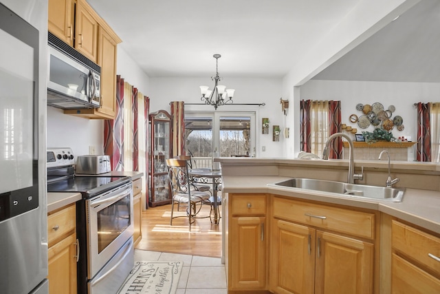 kitchen with light tile patterned flooring, appliances with stainless steel finishes, light countertops, and a sink