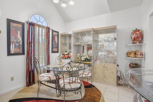 dining area with light tile patterned floors, baseboards, and lofted ceiling