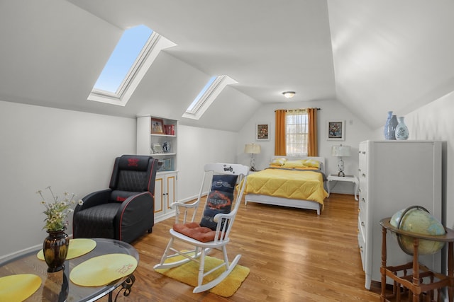 bedroom with lofted ceiling and light wood-style floors