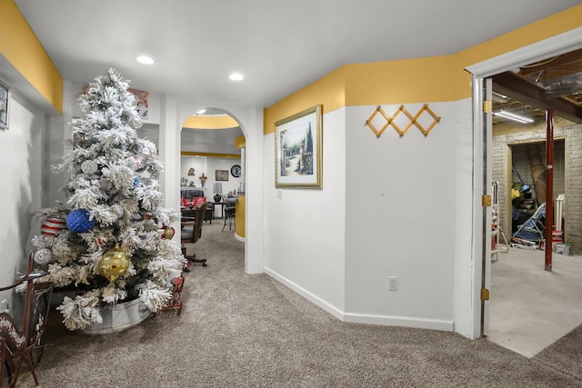 hallway featuring arched walkways, recessed lighting, baseboards, and carpet floors