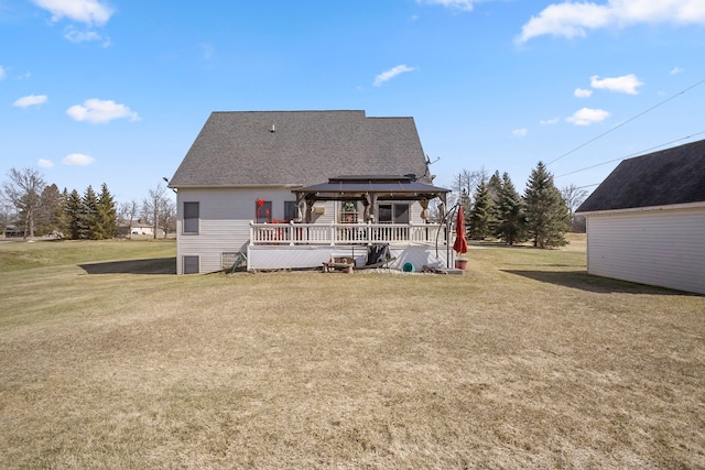 rear view of property with a gazebo, a yard, a wooden deck, and a shingled roof