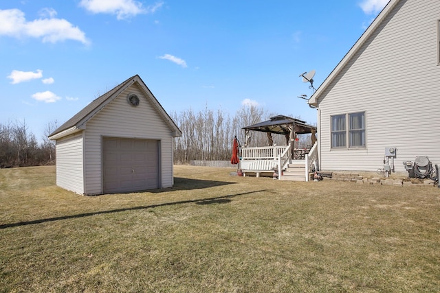 view of yard with an outbuilding, driveway, a gazebo, a garage, and a deck