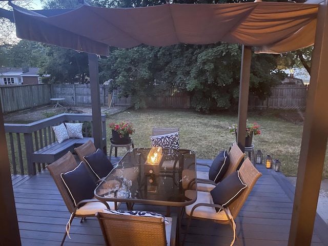 wooden deck with a fenced backyard and a fire pit