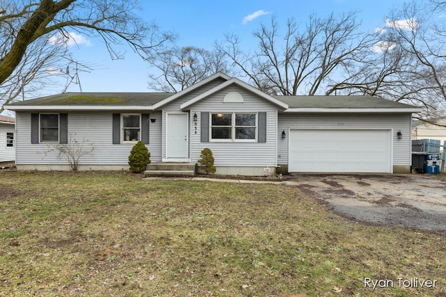 ranch-style home featuring an attached garage, aphalt driveway, and a front yard