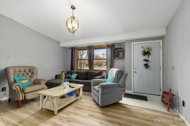 living area with light wood-type flooring and baseboards