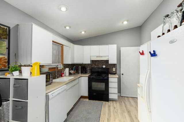 kitchen with under cabinet range hood, white appliances, a sink, white cabinetry, and light countertops