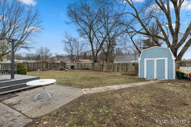 view of yard with an outbuilding, a patio, a storage unit, and a fenced backyard