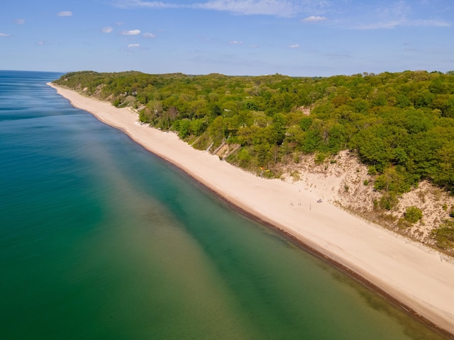 aerial view with a water view, a beach view, and a wooded view