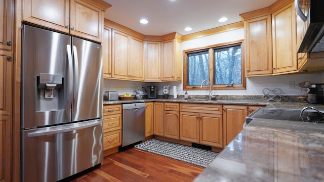 kitchen featuring dark wood-style floors, stainless steel appliances, recessed lighting, a sink, and under cabinet range hood