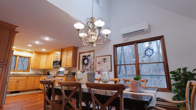 dining space with a baseboard radiator, a notable chandelier, recessed lighting, light wood-style floors, and a wall mounted air conditioner