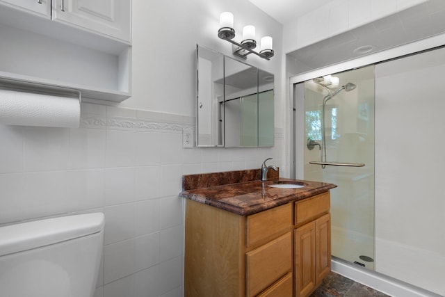 full bathroom with toilet, a stall shower, tile walls, and vanity