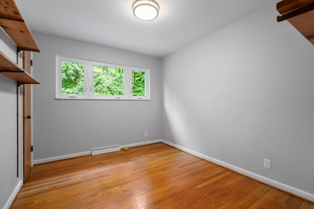 empty room featuring baseboards and light wood finished floors